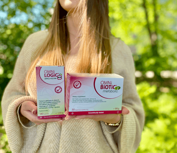 Zestaw OMNi-BiOTiC® Metabolic i OMNi-LOGiC® APPLE PECTIN trzymany w dłoniach
